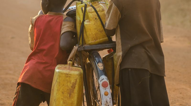Dos niños en Nigeria transportan bidones de agua